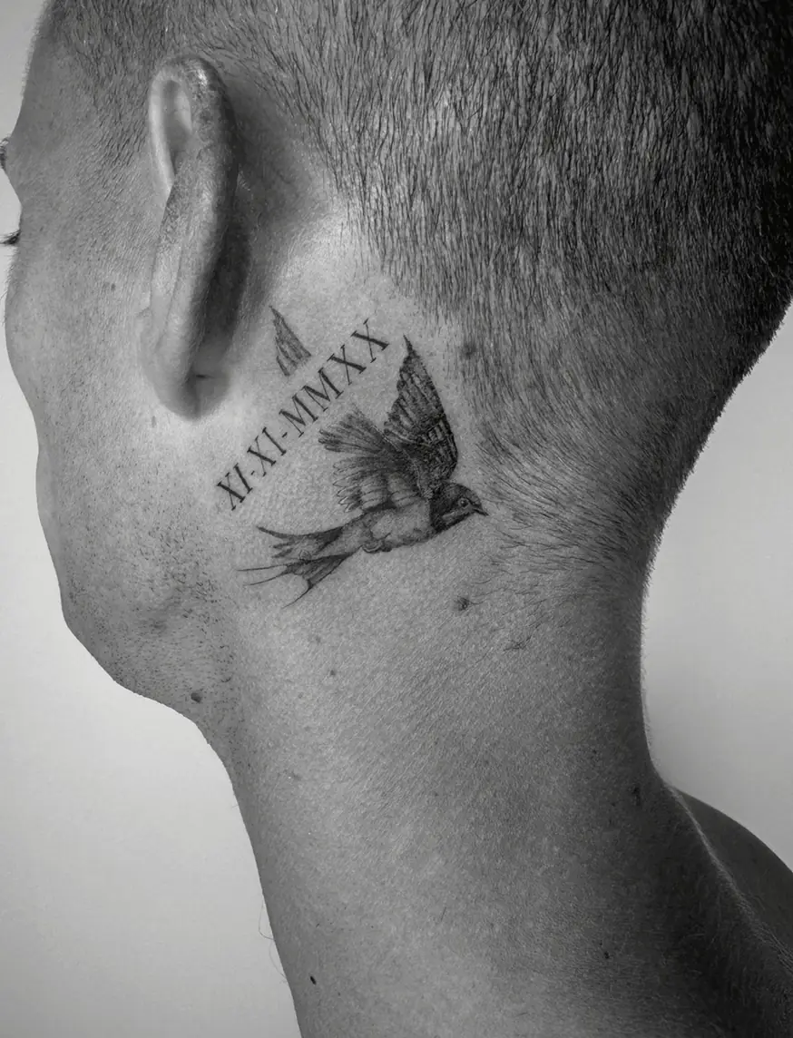 Small swallow in flight with a Roman numeral date, behind the ear on the side of the neck.