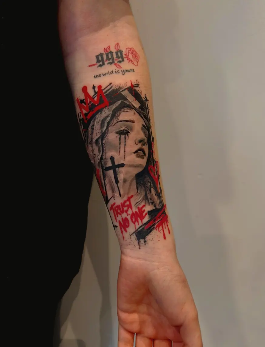 Red and black trash-polka style portrait of a crowned woman with a cross and lettering, on a forearm.